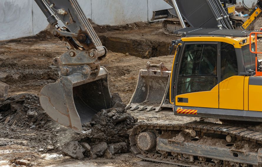 Excavator digging test pits for septic design